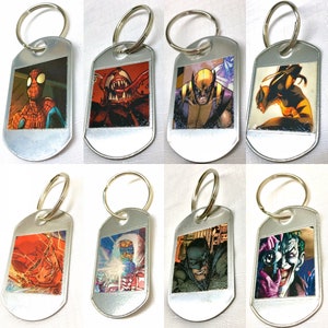 Peut inclure: Huit porte-clés argentés avec des images de différents personnages de bandes dessinées. Les personnages incluent Spider-Man, Venom, Wolverine, Black Widow, Flash, Mr. Freeze, Batman et Joker.