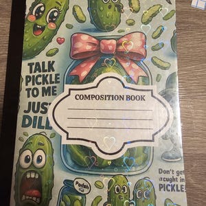 Peut inclure: Cahier de composition sur le thème des cornichons. La couverture présente des cornichons de dessins animés, un bocal avec un nœud rose et le texte "Talk Pickle to Me Just Dill". Le cahier porte une étiquette "Composition Book".