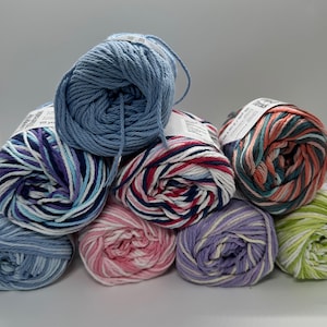 May include: A collection of colorful yarn skeins in various shades of blue, purple, pink, red, green, and orange. The yarn is tightly wound, and some skeins have labels. Ideal for knitting or crocheting projects.