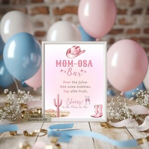 Könnte beinhalten: Ein gerahmtes Schild mit dem Text "MOM-OSA Bar" in Rosa, mit einer Cowboyhut-Illustration. Das Schild enthält Anweisungen für einen Cocktail und dekorative Elemente wie einen Kaktus und Cowboy-Stiefel. Ballons in Rosa, Weiß und Blau sind im Hintergrund.