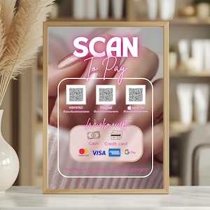 May include: A framed sign with the text "SCAN To Pay" in pink neon lettering. The sign displays QR codes for Venmo, PayPal, and Apple Pay, along with accepted payment methods: cash, credit card, Mastercard, Visa, American Express, and Google Pay. The sign reads "THANK YOU FOR YOUR SUPPORT."