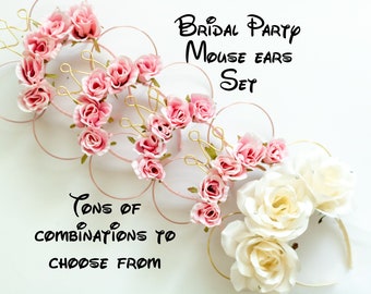 May include: Set of pink and white floral mouse ears with gold wire accents. The ears are arranged in a circle with the text "Bridal Party Mouse Ears Set" above them. The text "Tons of combinations to choose from" is below the ears.