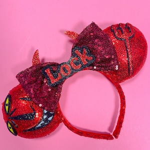 Puede incluir: Orejas de Minnie Mouse de lentejuelas rojas y negras con un lazo rojo y la palabra "Lock" en letras negras.