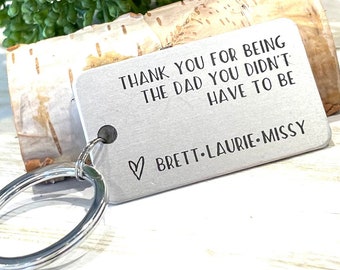 May include: Silver keychain with the text "Thank you for being the dad you didn't have to be" and a heart with the names "Brett-Laurie-Missy".