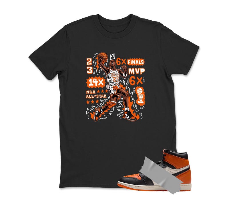 May include: Black t-shirt featuring a basketball player graphic in orange and white, with text including "23", "14X NBA All-Star", and "6X Finals MVP". An orange and black high-top sneaker is taped to the bottom of the shirt.