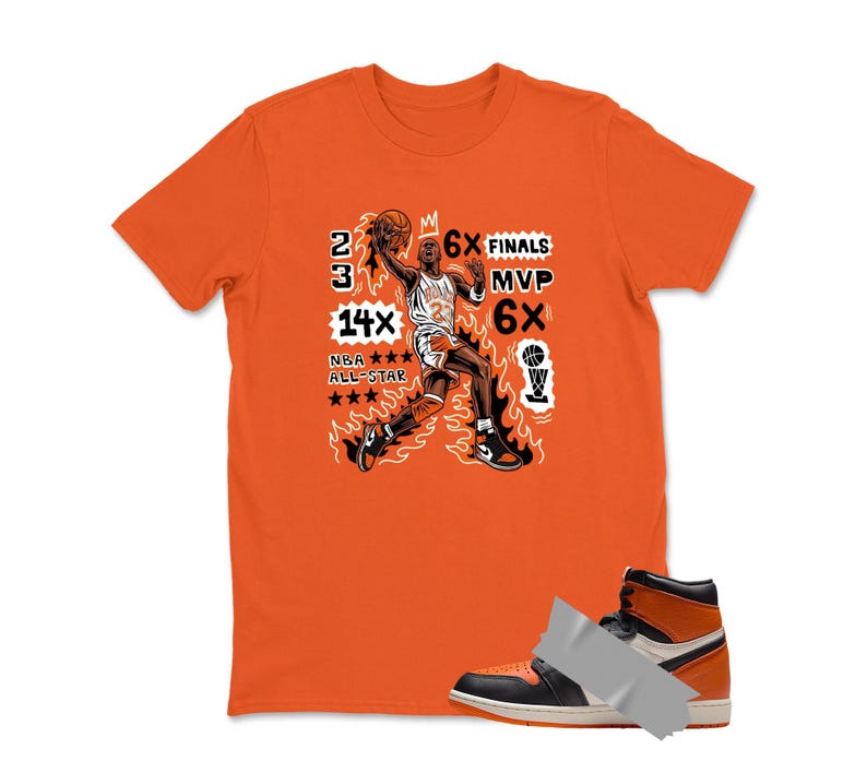 May include: Orange t-shirt with a graphic of a basketball player in action, flames, and text. The text includes "23", "6X Finals", "MVP", "6X", "14X NBA All-Star". A black, white, and orange high-top sneaker is in the foreground.