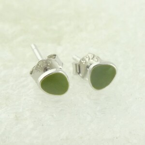 Puede incluir: Un par de pendientes de plata con detalles de piedra verde.
