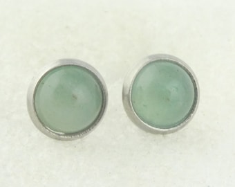 May include: A pair of silver stud earrings with light green round gemstones.
