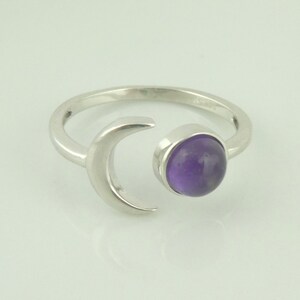Peut inclure: Une bague en argent avec un motif de croissant de lune et une pierre précieuse d'améthyste violette.