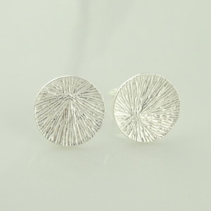 Peut inclure: Une paire de boucles d'oreilles en argent avec un motif circulaire texturé.