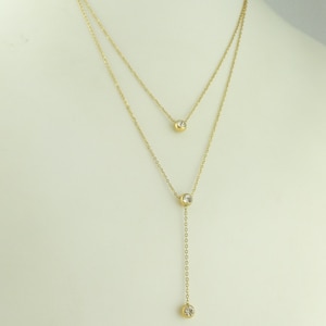 Peut inclure: Un collier à deux rangs en or avec trois accents de cristal transparent.