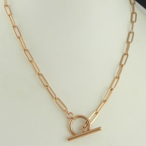 Könnte beinhalten: Eine goldene Kettenkette mit einem Toggle-Verschluss. Die Kette besteht aus ovalen Gliedern.