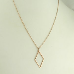 May include: A rose gold necklace with a delicate diamond-shaped pendant.