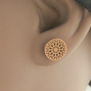 May include: A pair of brown, round earrings with a delicate, intricate, laser-cut design.