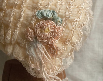 Cappello originale vintage in lana color vaniglia con nastri di raso, per neonato o bambola. 1920-30.