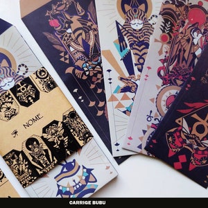 Peut inclure: Un ensemble de six enveloppes décoratives avec un schéma de couleurs noir, or et rouge. Les enveloppes présentent une créature féline avec des motifs d'inspiration égyptienne et le mot "NOME" imprimé sur deux des enveloppes.