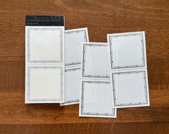 Puede incluir: Un conjunto de seis etiquetas de papel blanco con bordes decorativos negros. Las etiquetas están dispuestas en dos filas de tres. Las etiquetas están en blanco y listas para escribir. Las etiquetas están empaquetadas en una caja blanca y negra con el texto "LETTERPRESS PRINTING PROCESS #20319-01".