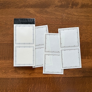 Puede incluir: Un conjunto de seis etiquetas de papel blanco con bordes decorativos negros. Las etiquetas están dispuestas en dos filas de tres. Las etiquetas están en blanco y listas para escribir. Las etiquetas están empaquetadas en una caja blanca y negra con el texto "LETTERPRESS PRINTING PROCESS #20319-01".