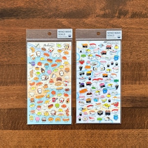 May include: Two packs of stickers featuring Japanese food. One pack has a variety of bakery items with the text "Yummal Bakery" and the other pack has a variety of sushi with the text "O-SUSHI-G!" Both packs have the text "Mind Wave Seals Original Designs".