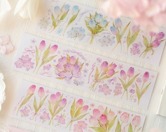 Puede incluir: Tres hojas de cinta adhesiva washi decorativa con ilustraciones de acuarela de tulipanes rosas y azules con delicados detalles florales. La cinta es perfecta para agregar un toque de fantasía a diarios, planificadores y otras manualidades de papel.