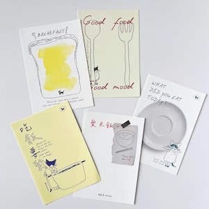 May include: A collection of illustrated cards with food-related themes. One card features toast with butter, another says "Good food, good mood," and a third asks "What did you eat today?" The cards have whimsical drawings and text.