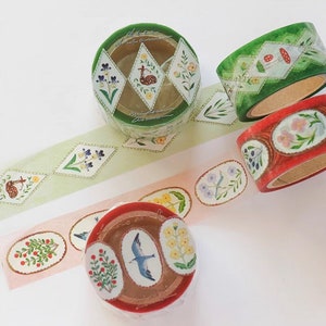 May include: Four rolls of washi tape with floral and nature designs. The tapes feature a variety of colours, including green, red, and pink. The designs include flowers, birds, and mushrooms.
