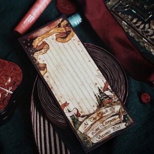 May include: A vintage-style bookmark with a cream-colored background and vertical stripes. The bookmark features decorative banners with text, including "If You Never Wake Up" and "At The Touch of Love Everyone Becomes Poet". The design includes a castle illustration.