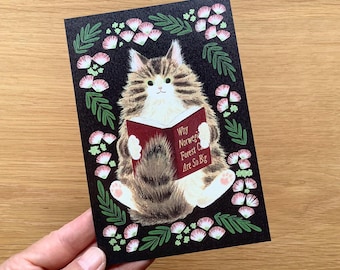 Op de afbeelding: Een zwarte wenskaart met een pluizige kat die een boek leest met de titel "Why Norwegian Forest Cats Are So Big". De kat is omgeven door een bloemenrand van groene bladeren en roze en witte bloemen. De kat is bruin, wit en bruin.