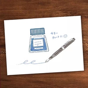 May include: A blue ink bottle with the text "wasure nagusa" and a black fountain pen with a blue ink line drawn on a white background. The text "カラーチャートに" is written in Japanese.