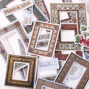 May include: A collection of rectangular paper stickers featuring ornate, vintage-style picture frames in various colors and patterns. Some stickers include text such as Make A Wish and you mean so much to me, alongside a small illustration of red berries.