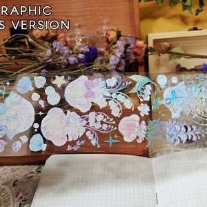 Puede incluir: Una hoja de pegatinas hologr&aacute;ficas con acabado en relieve. Las pegatinas presentan una variedad de dise&ntilde;os, incluyendo flores, conchas y estrellas. Las pegatinas son iridiscentes y tienen un efecto arco&iacute;ris.