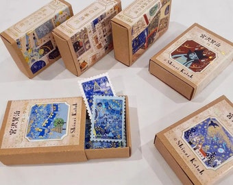 May include: A set of six small, brown cardboard boxes with colorful illustrations and text in Japanese. The boxes are decorated with a blue and gold starry night theme. The text on the boxes includes "Shinzi Katoh" and "Galaxy Railroad Night".