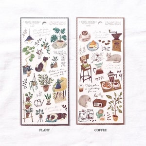 May include: Two sheets of stickers featuring illustrations of plants and coffee. The plant sheet has a dog, a watering can, and a ladder. The coffee sheet has a cat, a coffee grinder, and a cup of coffee. Both sheets have the text "Snug Room" at the top.