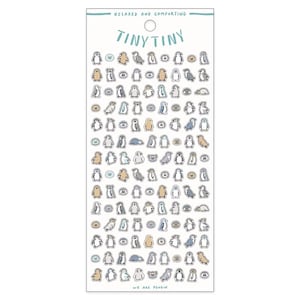 May include: A sheet of stickers featuring a variety of penguin illustrations in blue, gray, and beige. The stickers are arranged in rows and columns on a white background. The text "TINY TINY" is printed in blue at the top of the sheet. The text "WE ARE PENGUIN" is printed in blue at the bottom of the sheet.