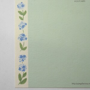May include: A light green postcard with a border of blue flowers and green stems on the left side. The text "POSTCARD" is in the top right corner. The text "http://4legsfactory.n" is in the bottom right corner.