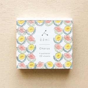 May include: A white notebook with a floral pattern in pink, yellow, and green. The notebook has the text "admi Chorus 4 patterns 120 sheets" printed on the front.