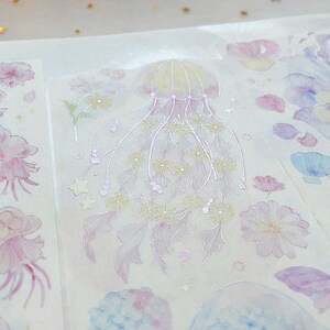 Puede incluir: Una hoja de pegatinas transparentes con un dise&ntilde;o de acuarela de medusas, flores y otras criaturas marinas. Las pegatinas son perfectas para a&ntilde;adir un toque de fantas&iacute;a a tu agenda, diario o &aacute;lbum de recortes.