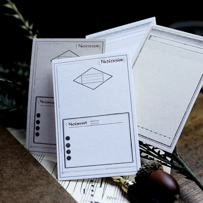 May include: Three white note cards with black borders and different designs. The top card has a lined rectangle, the middle card has a diamond shape with lines, and the bottom card has a blank rectangle with a list of bullet points. Each card has a number printed on it, "No.765315698".