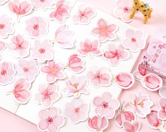May include: A sheet of pink and white floral stickers with a variety of flower designs. The stickers are perfect for adding a touch of whimsy to journals, planners, and other paper crafts.