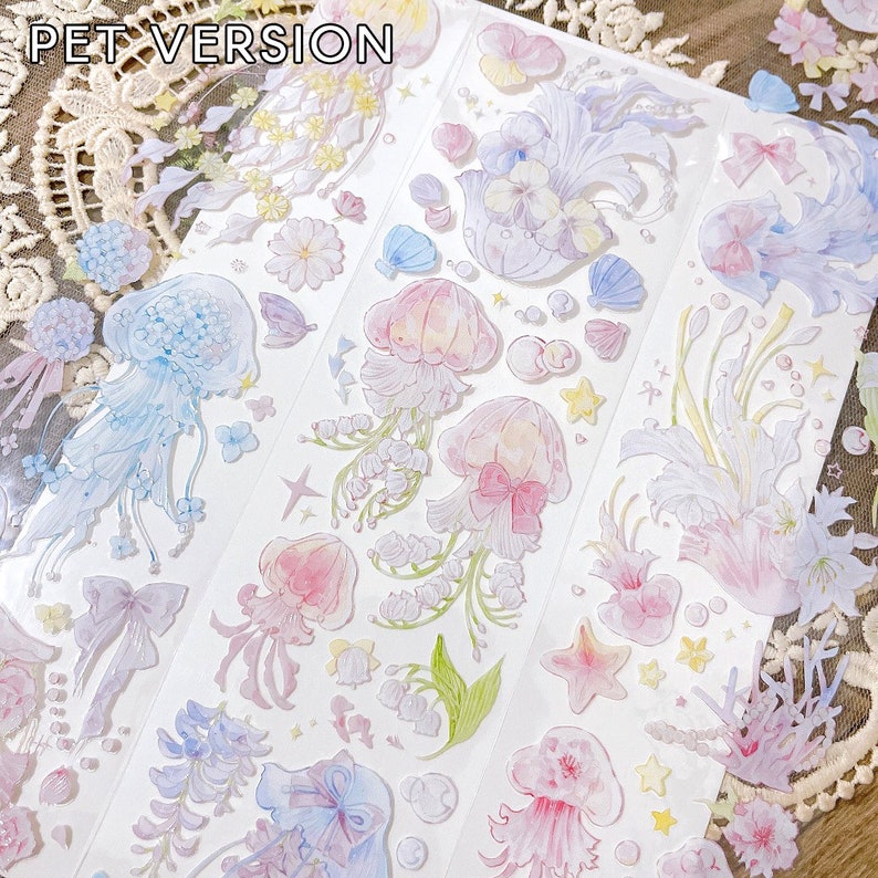 Puede incluir: Una hoja de pegatinas transparentes con una variedad de dise&ntilde;os en colores pastel, incluyendo medusas, flores y estrellas. Las pegatinas est&aacute;n etiquetadas como "PET VERSION".