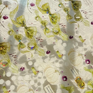 May include: A decorative sheet featuring a repeating pattern of watercolour bows, ribbons, and white pumpkins. The design includes small purple gems, floral elements, and text that reads "White Green Dandelion". The background is a textured white surface.