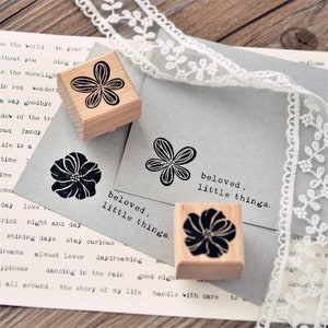 May include: Three wooden stamps with floral designs and the text "beloved, little things".