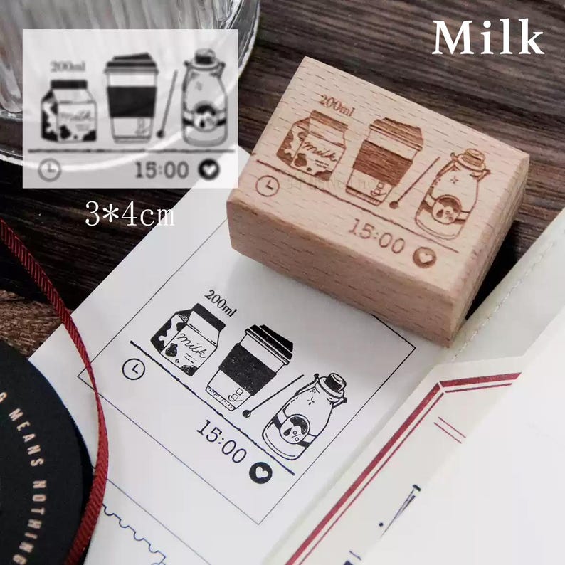 May include: A wooden stamp with a design of a milk carton, a cup of coffee, and a milk bottle. The stamp is 3 by 4 centimeters and has the text "200ml", "Milk", "15:00", and a heart symbol.