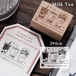 May include: Wooden stamp with a design of three cups of milk tea with boba. The stamp is 3 inches by 4 inches and says "Milk Tea" and "teatime" in cursive. The stamp is made in Japan and is part of the "CLASSIKY" brand.
