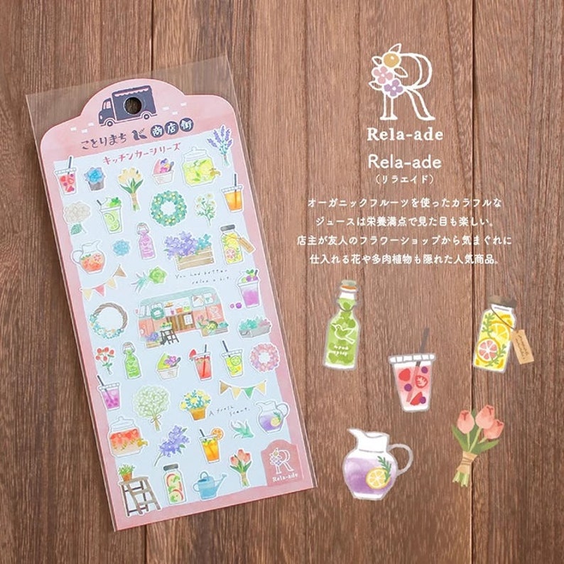 May include: A sheet of colorful stickers featuring a variety of illustrations, including a food truck, flowers, and drinks. The stickers are designed with a whimsical, hand-drawn style. The text on the sheet reads "Rela-ade (Lila-aid)" and "Kitchen Car Series".