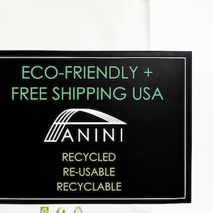 Op de afbeelding: Zwart-witte afbeelding met de tekst "ECO-FRIENDLY + FREE SHIPPING USA" en het woord "ANINI" in een gestileerd lettertype. De afbeelding bevat ook een gestileerde boogbrug en de woorden "RECYCLED", "RE-USABLE" en "RECYCLABLE".