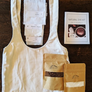 May include: Natural dye kit with four fabric swatches: cotton, bamboo-rayon, silk, and a white tote bag. The kit includes two brown paper packets labeled "ANINI" with dye powder and a booklet titled "NATURAL DYE KIT DYE-IT-YOURSELF".