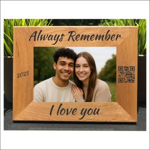 May include: A wooden picture frame with the words "Always Remember" and "I love you" engraved in black. The frame holds a photo of a smiling couple. The year "2025" is also engraved on the frame, along with a QR code.