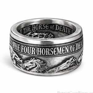A silver ring with a detailed engraved design featuring a dragon and the text "THE FOUR HORSEMEN OF DEATH".