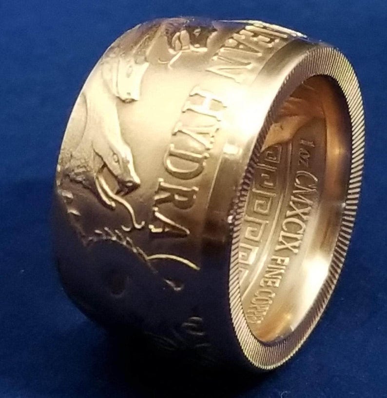 a close up of a gold ring on a blue surface